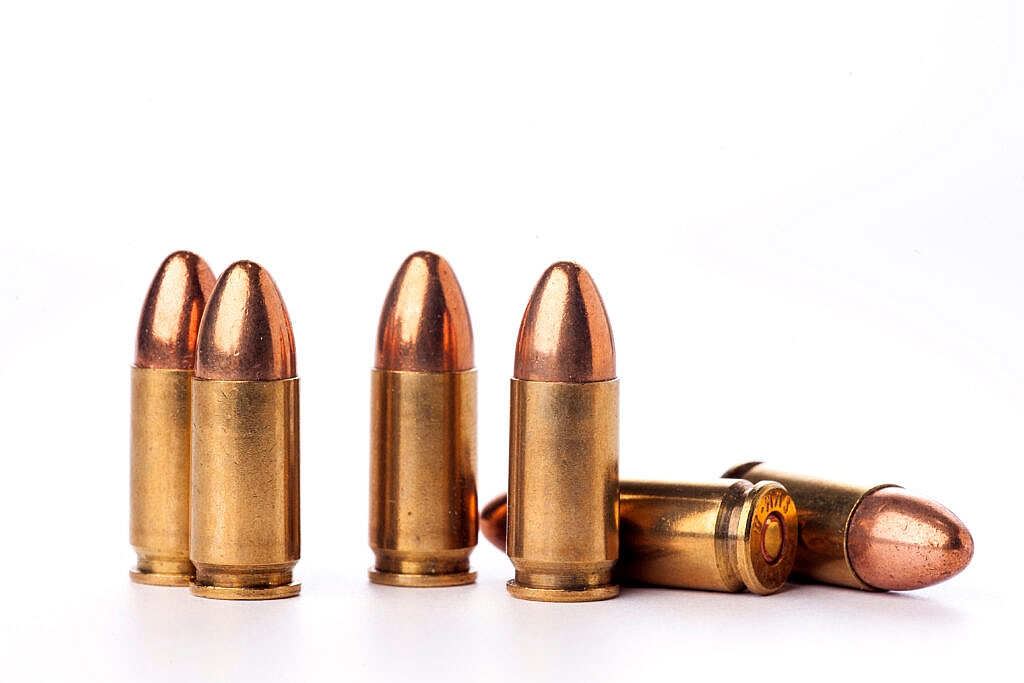 Close-up of various ammunition types including casings, bullets, and cartridges, displayed in neat rows to showcase their design and size differences.